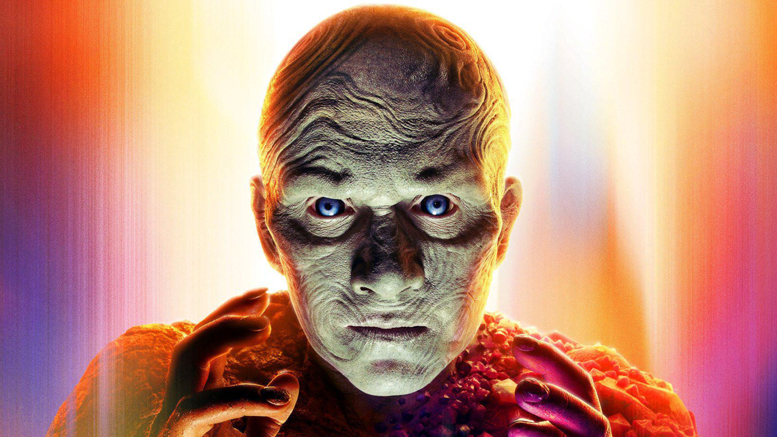A weird-looking bald superhero with luminous blue eyes