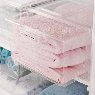 Pink towels folded in labelled acrylic box