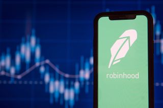 The Robinhood logo displayed on a mobile phone with a stock trading chart in the background