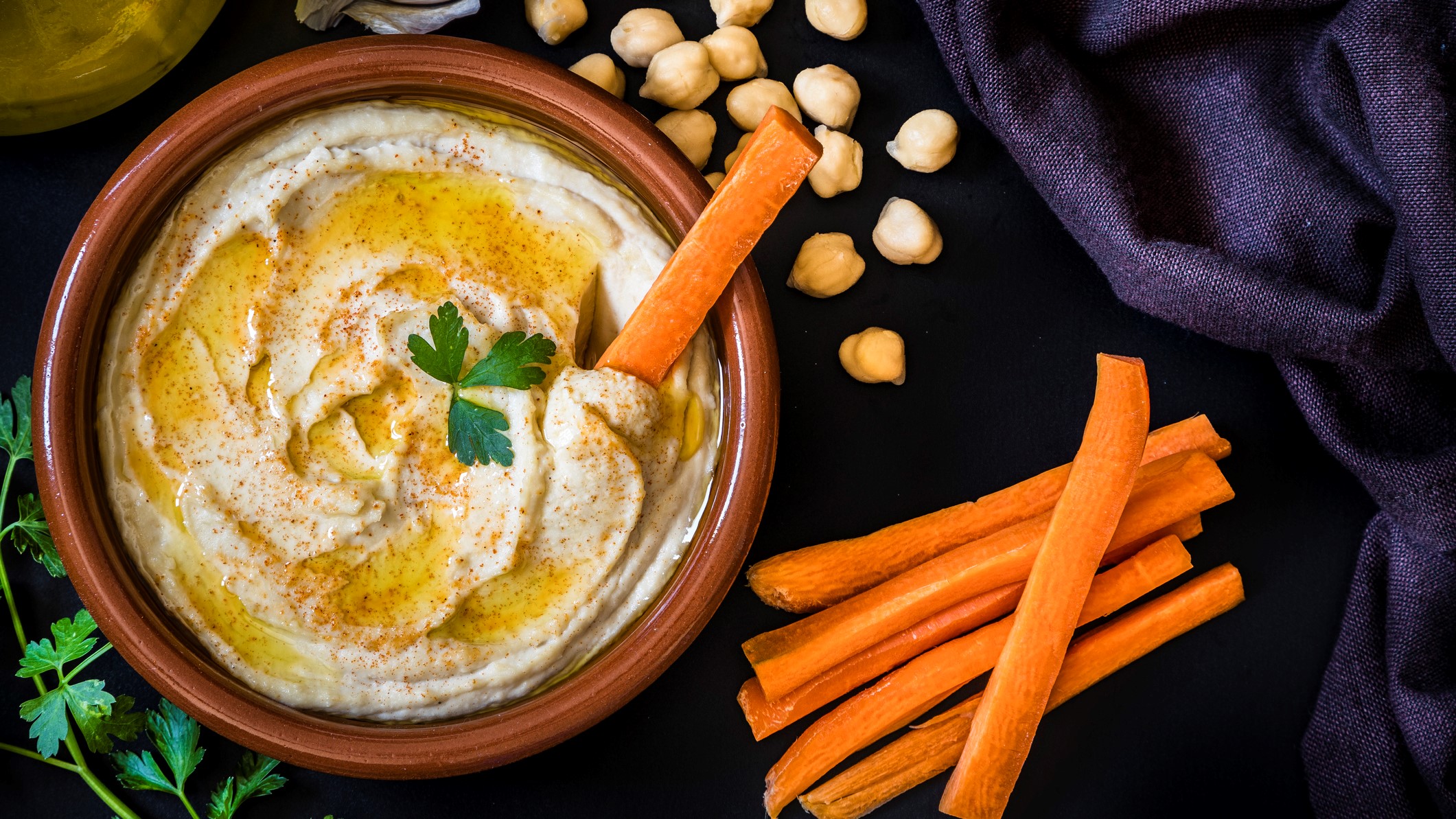 A photo of some hummus with carrot sticks