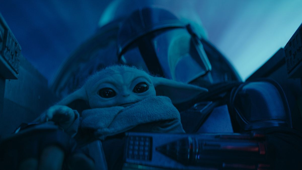 Din Djarin holds onto Grogu in his starfighter cockpit in The Mandalorian season 3