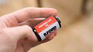 Ilford XP2 Super 35mm film canister held in a hand