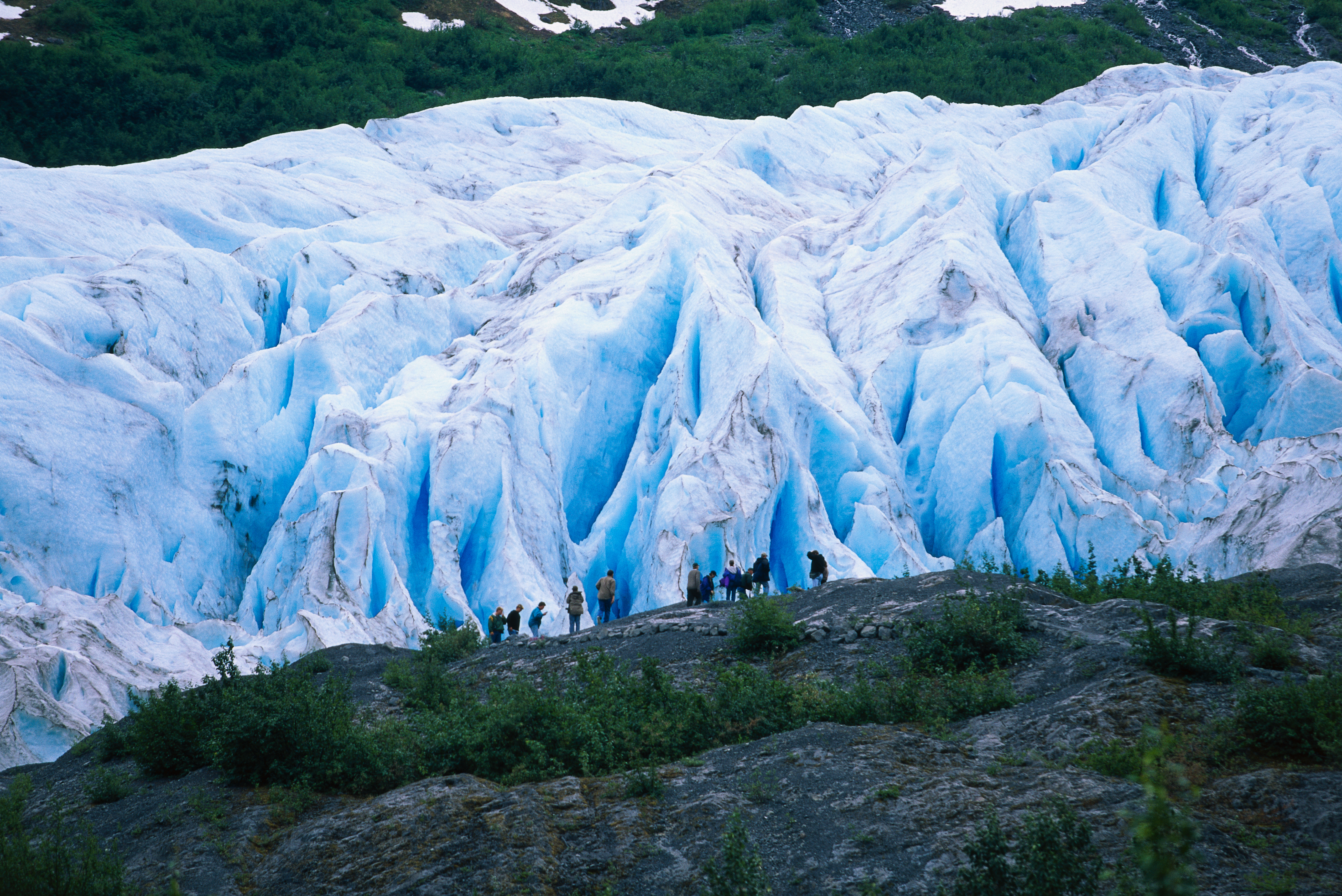 People stand in front of Exit Glacier in Alaska