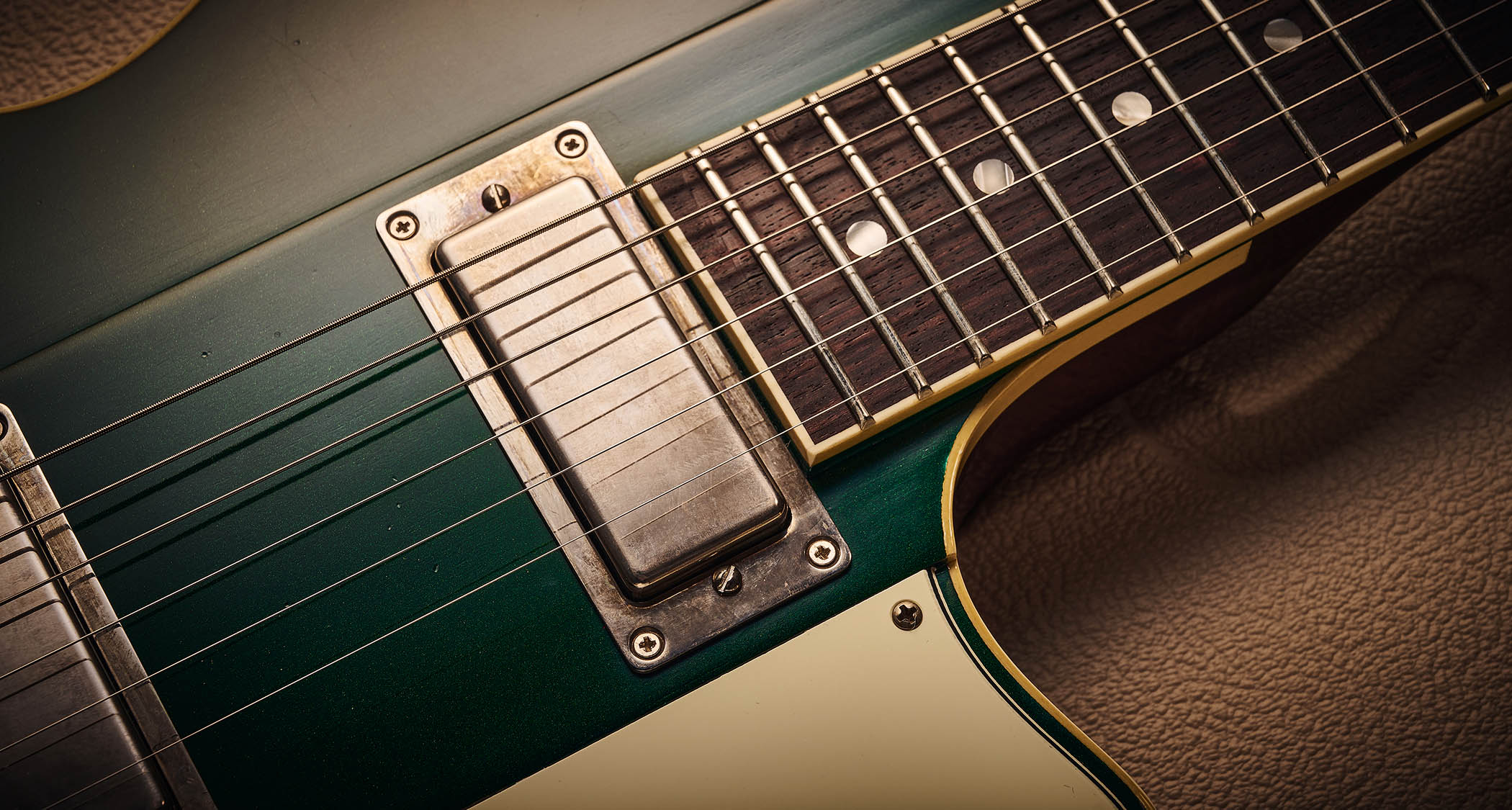 Ivison Dakota Standard in Cadillac Green photographed against its cream-covered Hiscox hard-shell guitar case.