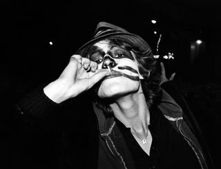 Person in halloween makeup including a hat smoking - dark and moody shot (night) - black and white