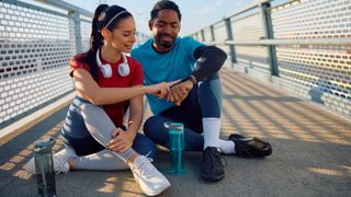 Man and woman checking sports watch after workout
