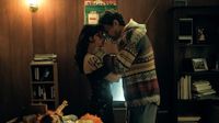A still from Obsession, as Bear and Nikki stand with their foreheads touching in a messy living room.