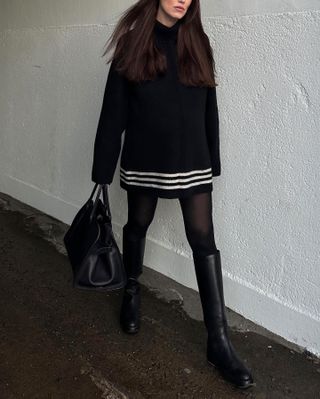 Woman wearing a black-and-white sweaterdress.