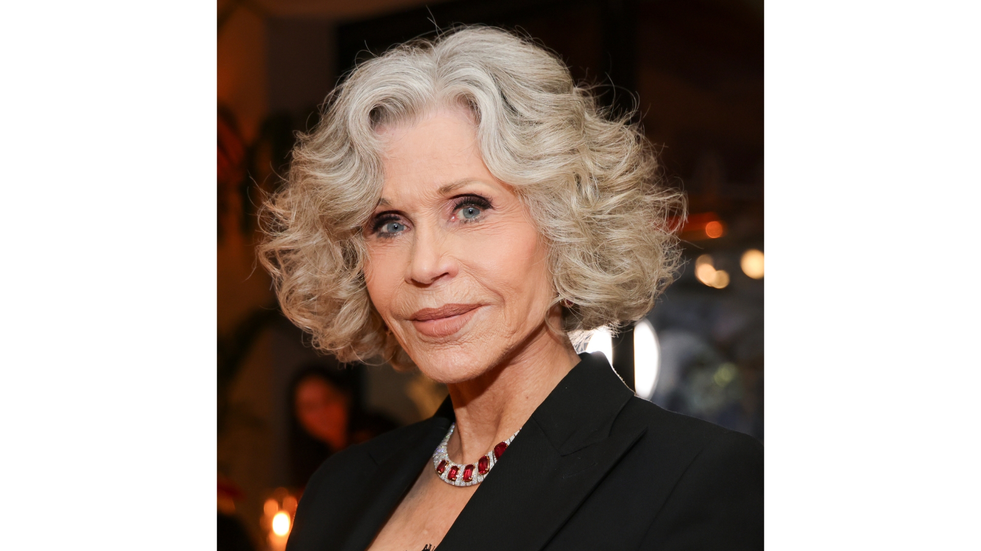 Image of Jane Fonda with a grey curly short bob and wearing a black blazer