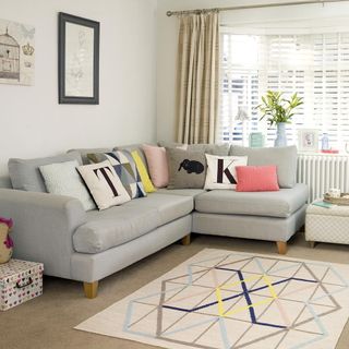 living room with art work frame on white wall and grey sofa set with cushions