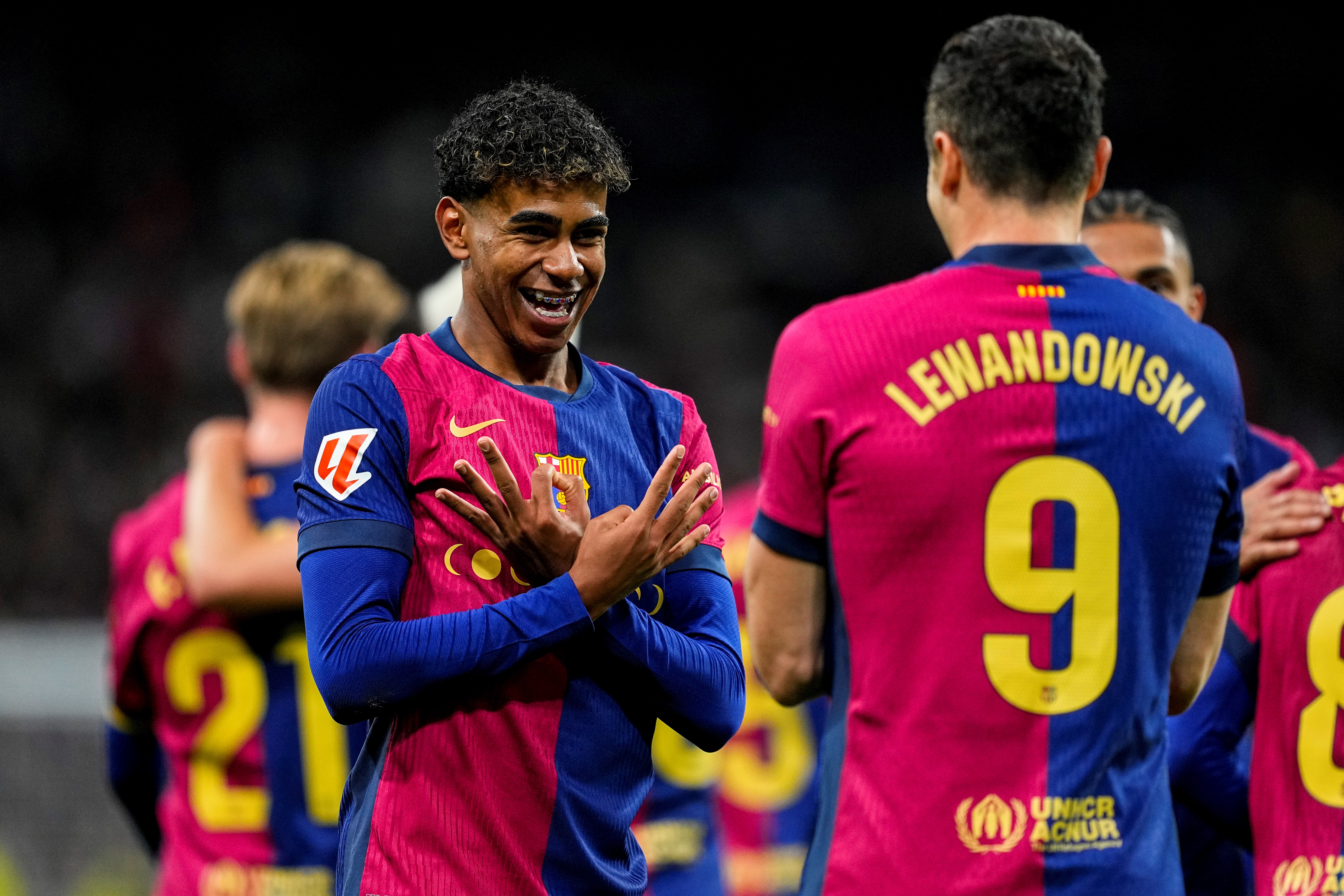 Lamine Yamal celebrates with Robert Lewandowski after scoring Barcelona's third goal in a big win against Real Madrid in October 2024.