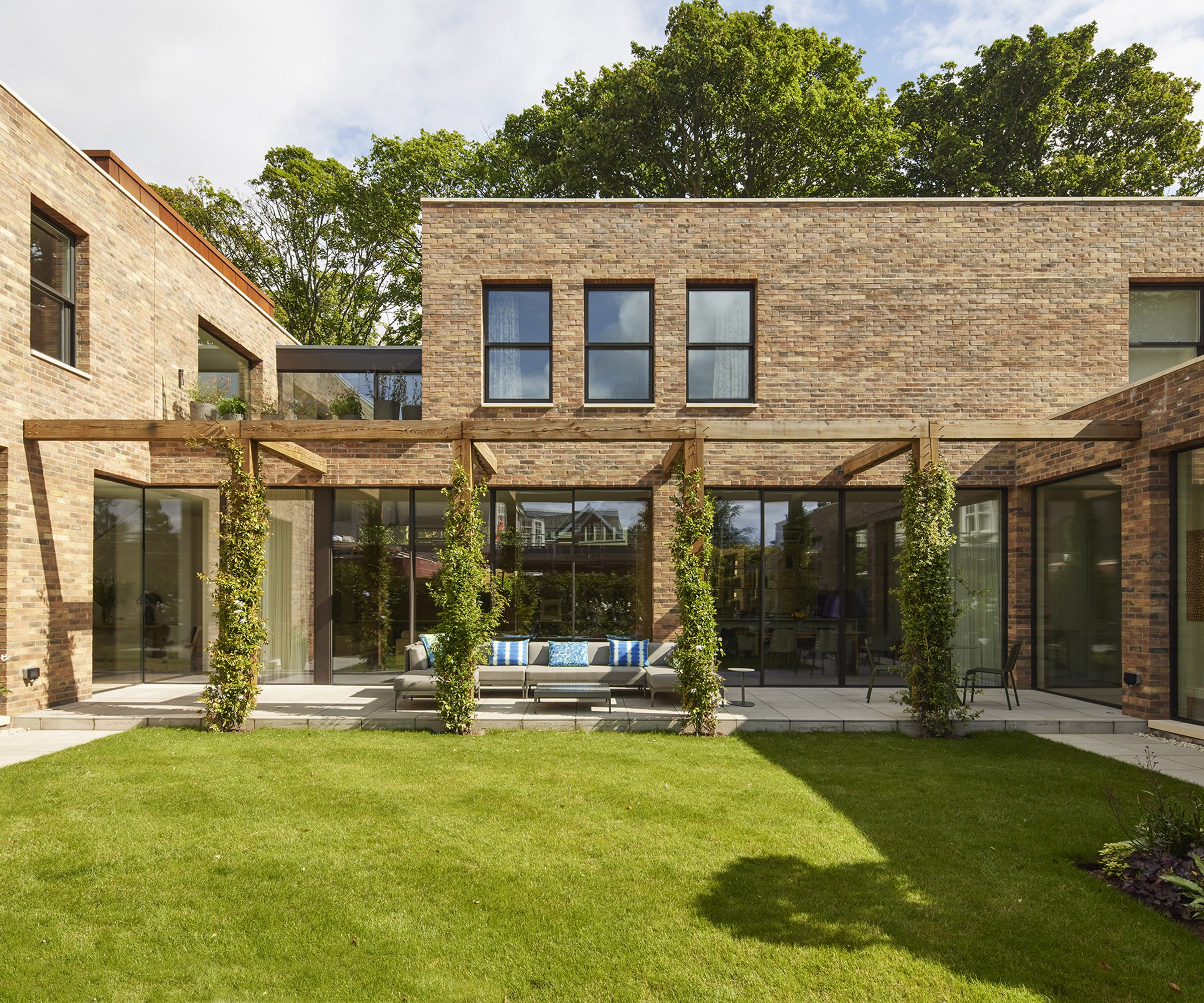 Exterior of a self build home clad in brick with lush lawn in front