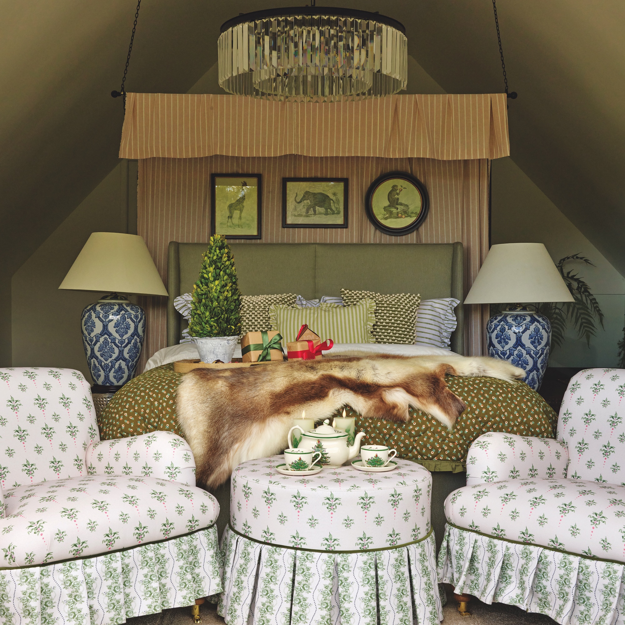 bedroom with double bed with canopy and two small armchairs with upholstered pouffe