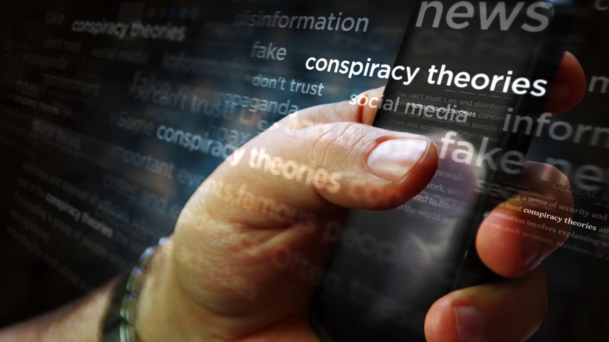 A close up of someone's hand holding a phone with the word "conspiracy theory" overlaid over the image