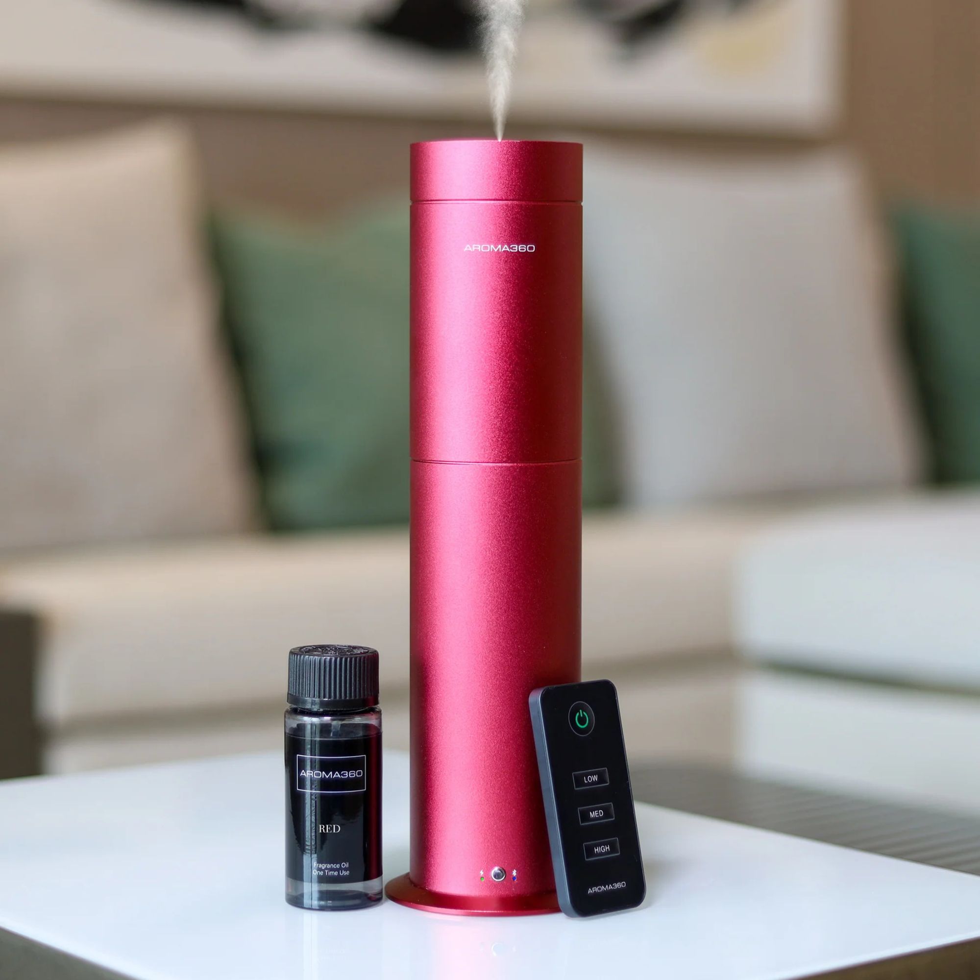 Aroma360 Wireless Pro Scent Diffuser on a table in front of a sofa.