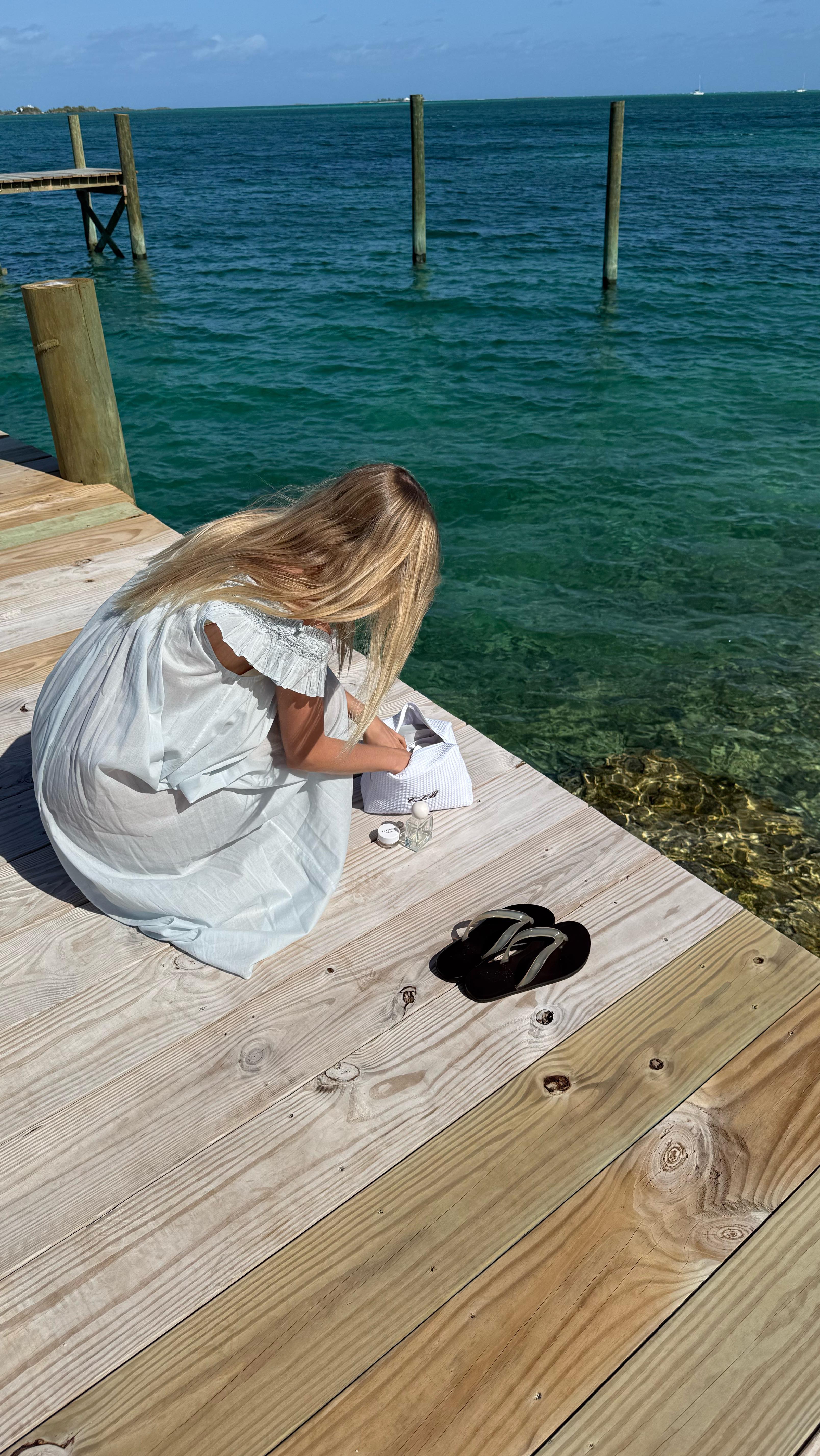 An image of @caitlinburnhamm wearing a holiday outfit consisting of Ancient Greek Saionara sandals and a blue Dôen dress.
