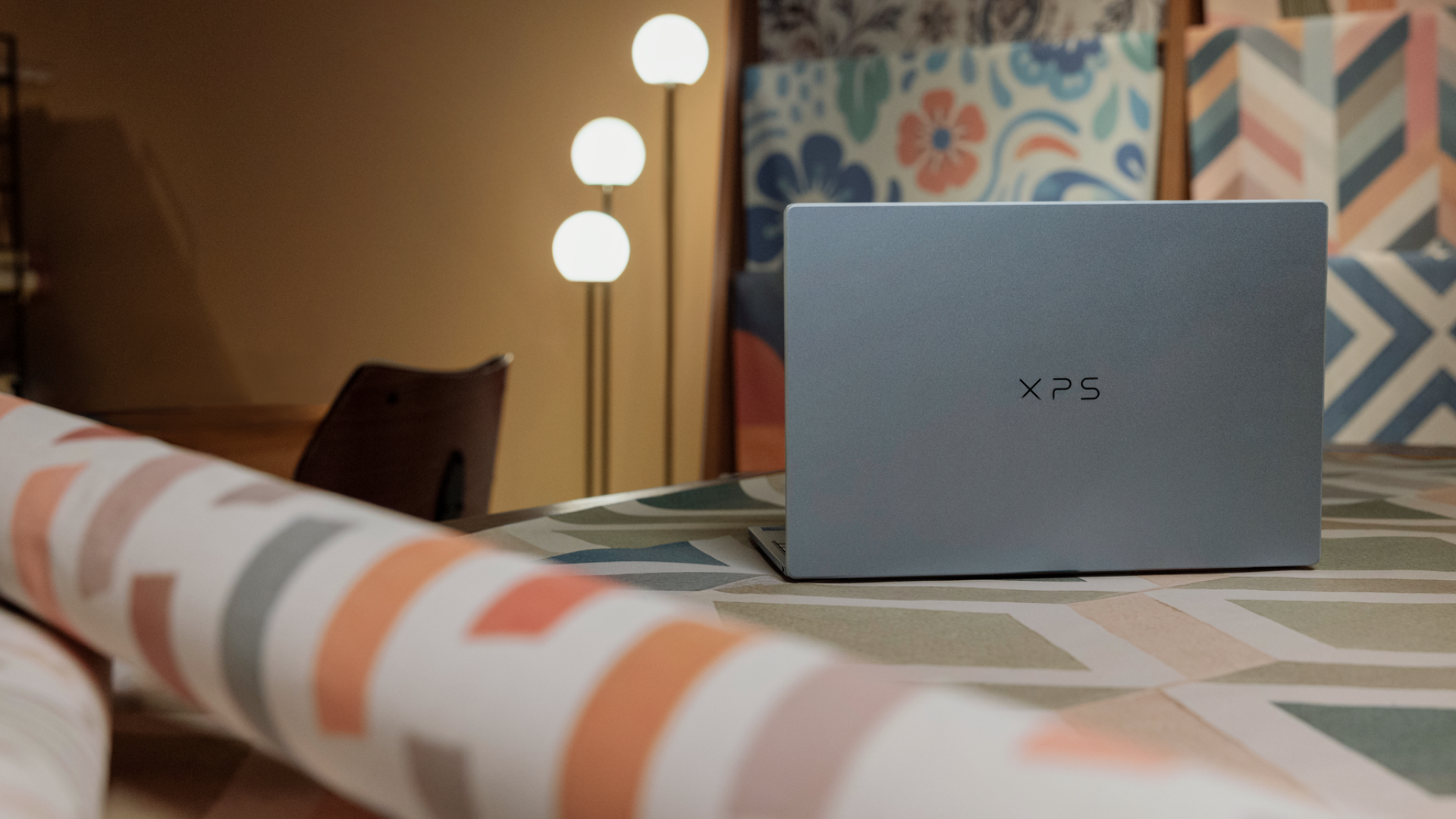 Dell XPS 14 on a table, viewed from the rear showing logo on lid