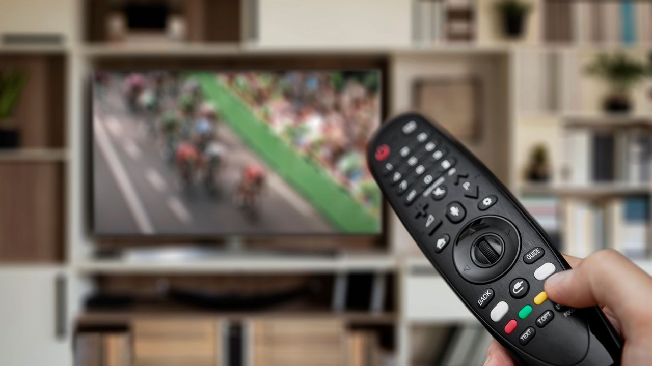 Remote control pointed at TV with bike race on the screen