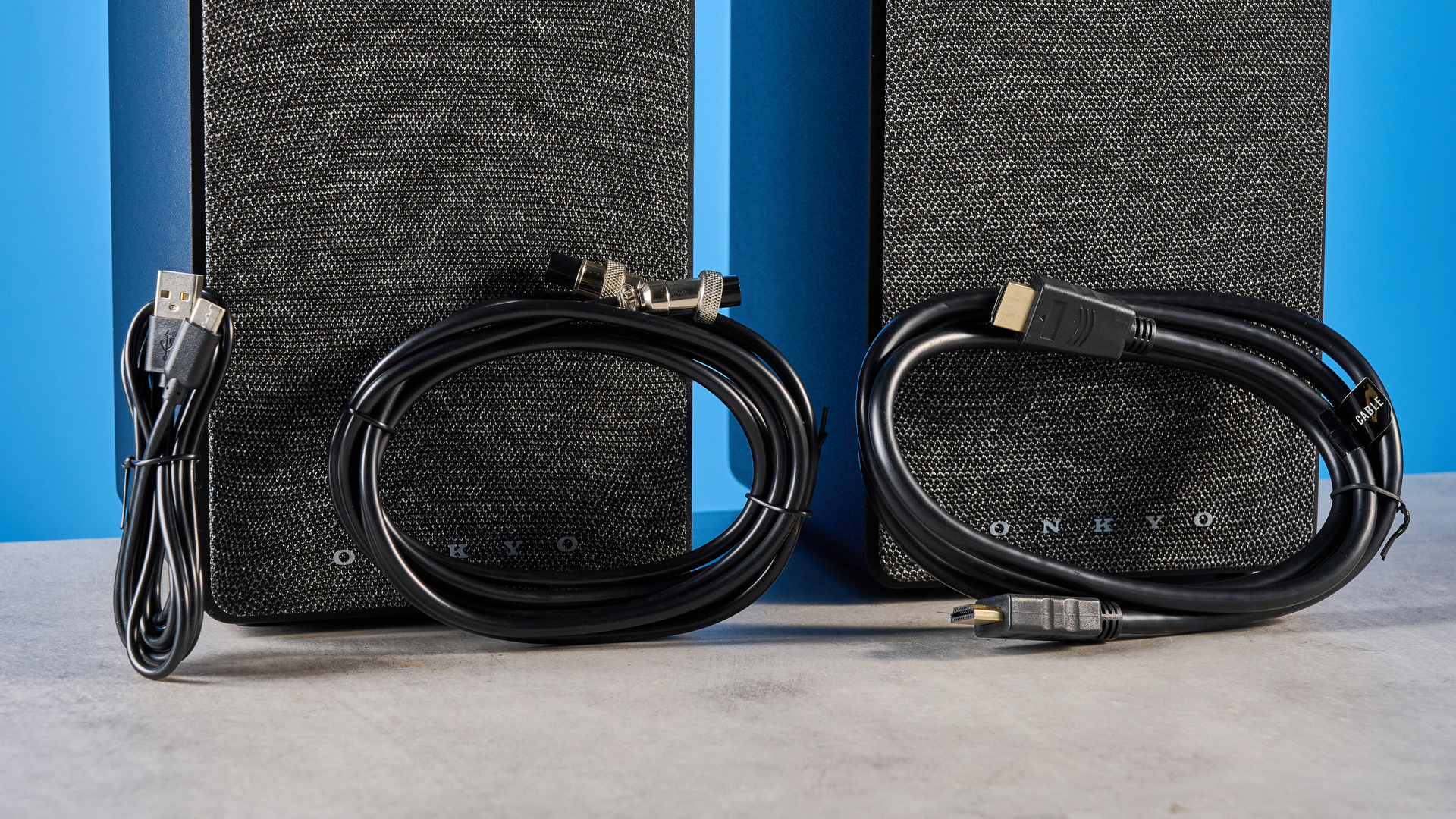 Onkyo GX-30ARC bookshelf speakers photographed on a blue background