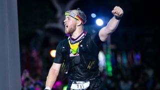 Billy crossing the finish line of the Kona Ironman Championships with his left arm raised in triumph.