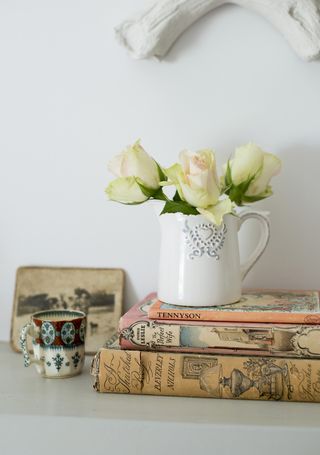 books with flowers in jug