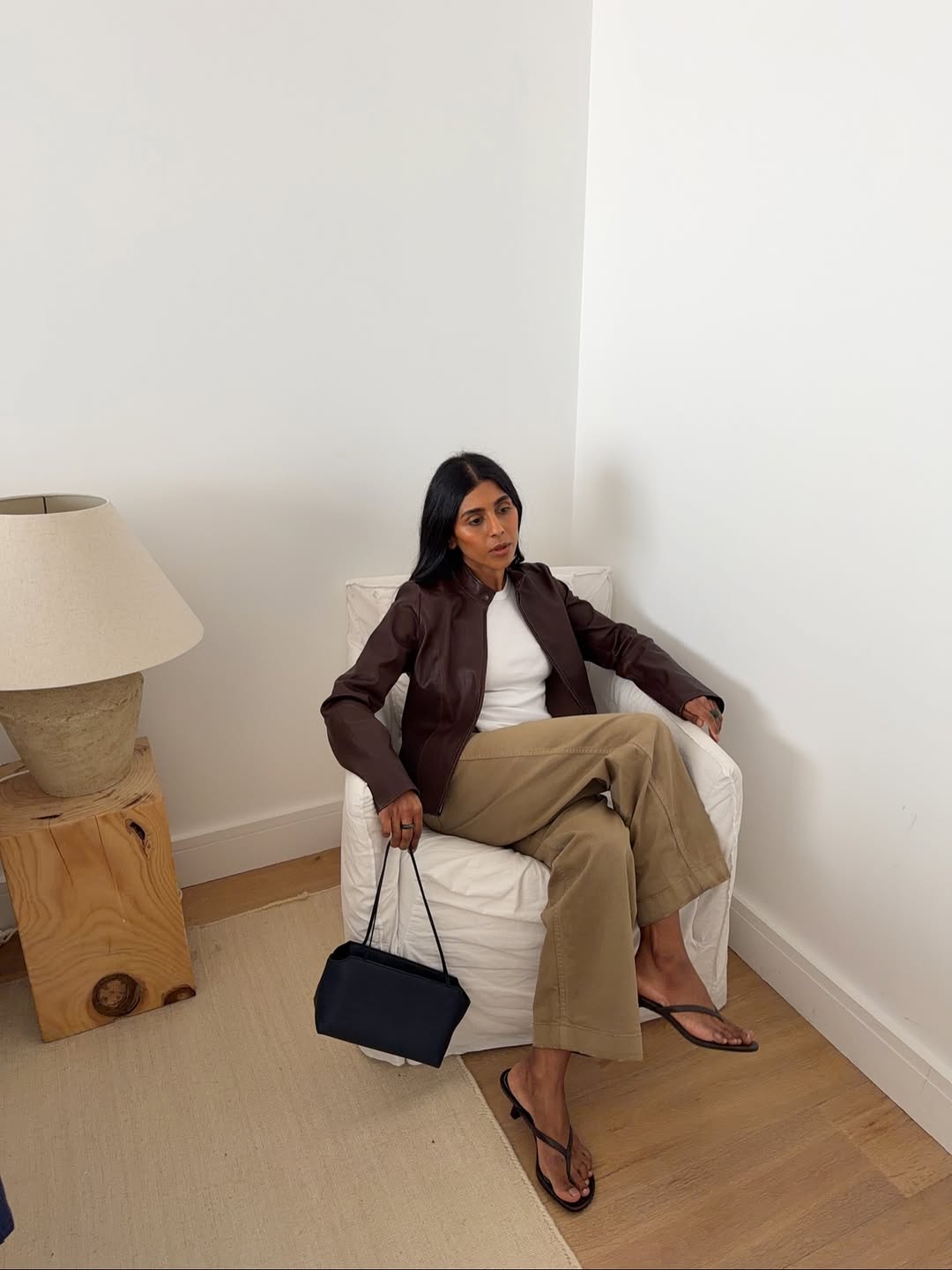 Monikh in khaki jeans and brown leather jacket