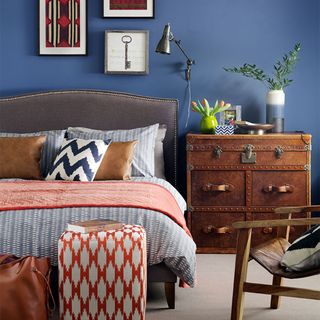 blue bedroom with grey bed and leather chest