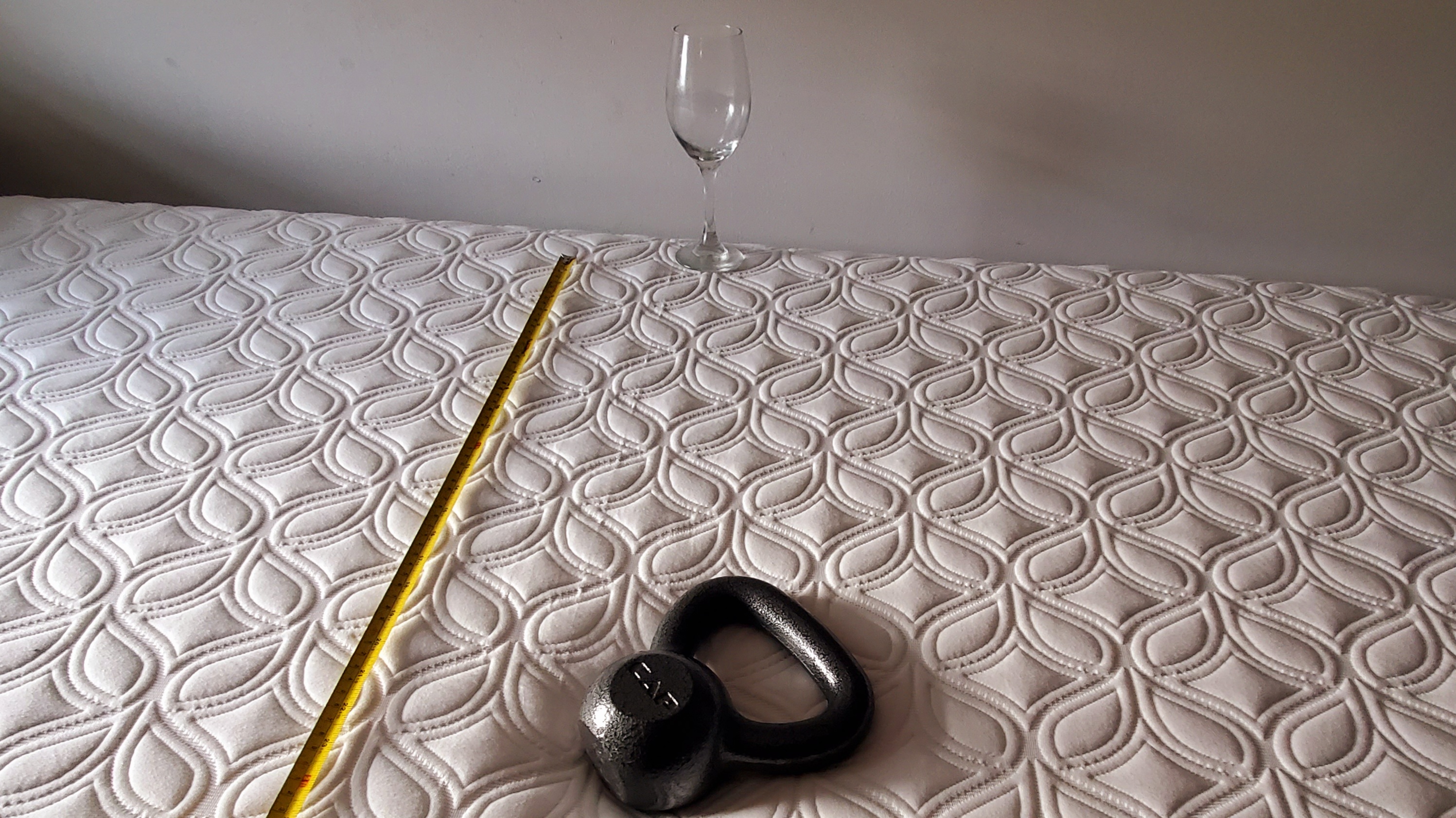 Cocoon by Sealy Chill mattress review, testing motion isolation with an empty wine glass, kettlebell, and tape measure