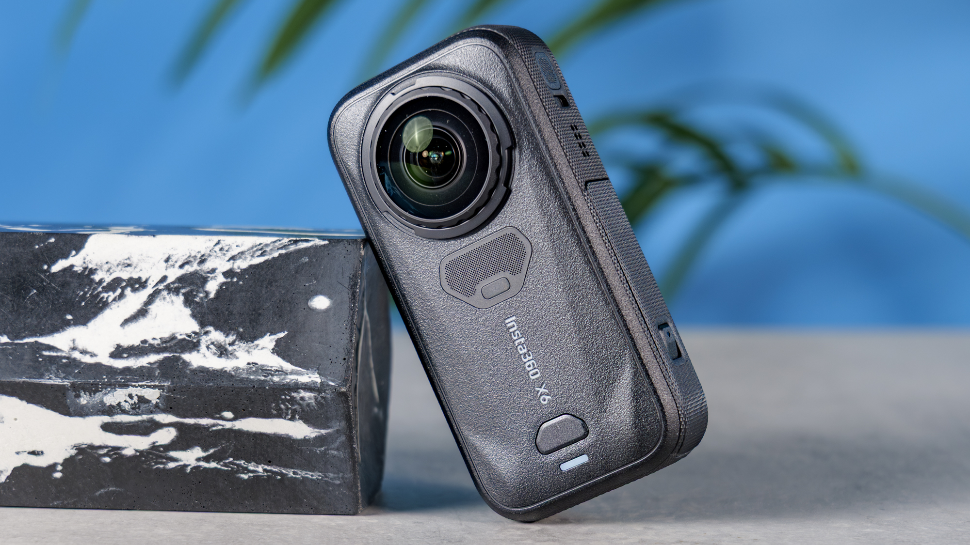 A photo of the Insta360 X6 on a stone surface, leaning on a marble plinth