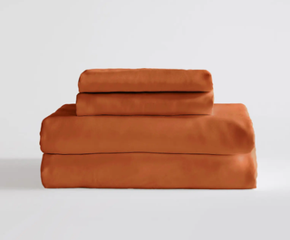 a stack of terracotta colored bedding