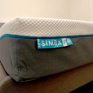 The corner of a mattress showing a blue label with white writing saying 'Simba Pro'