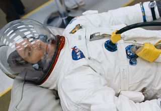 While seemingly resting, astronaut Jack Swigert, command module pilot for the Apollo 13 mission, prepares for the ensuing launch in the suiting room at NASA's Kennedy Space Center. Swigert replaced astronaut Ken Mattingly on the Apollo 13 crew when it was discovered that Mattingly had been exposed to the measles.