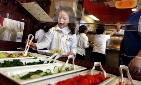 A Chicago elementary school student selects food from a salad bar.