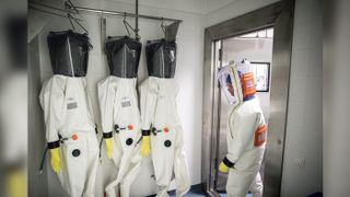 A scientist wearing a full-body protective suit enters the decontamination chamber after working in the biosafety level 4 (BSL-4) laboratory used for coronavirus research at the Szentgothai Research Center, University of Pecs, in Hungary, on April 27, 2020.