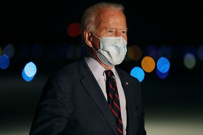 Wearing a face mask to reduce the risk posed by the coronavirus, Democratic presidential nominee Joe Biden talks to reporters before departing Cincinnati/Northern Kentucky International Airpo