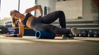 Woman laying on her right side in a side plank using the best foam rollers
