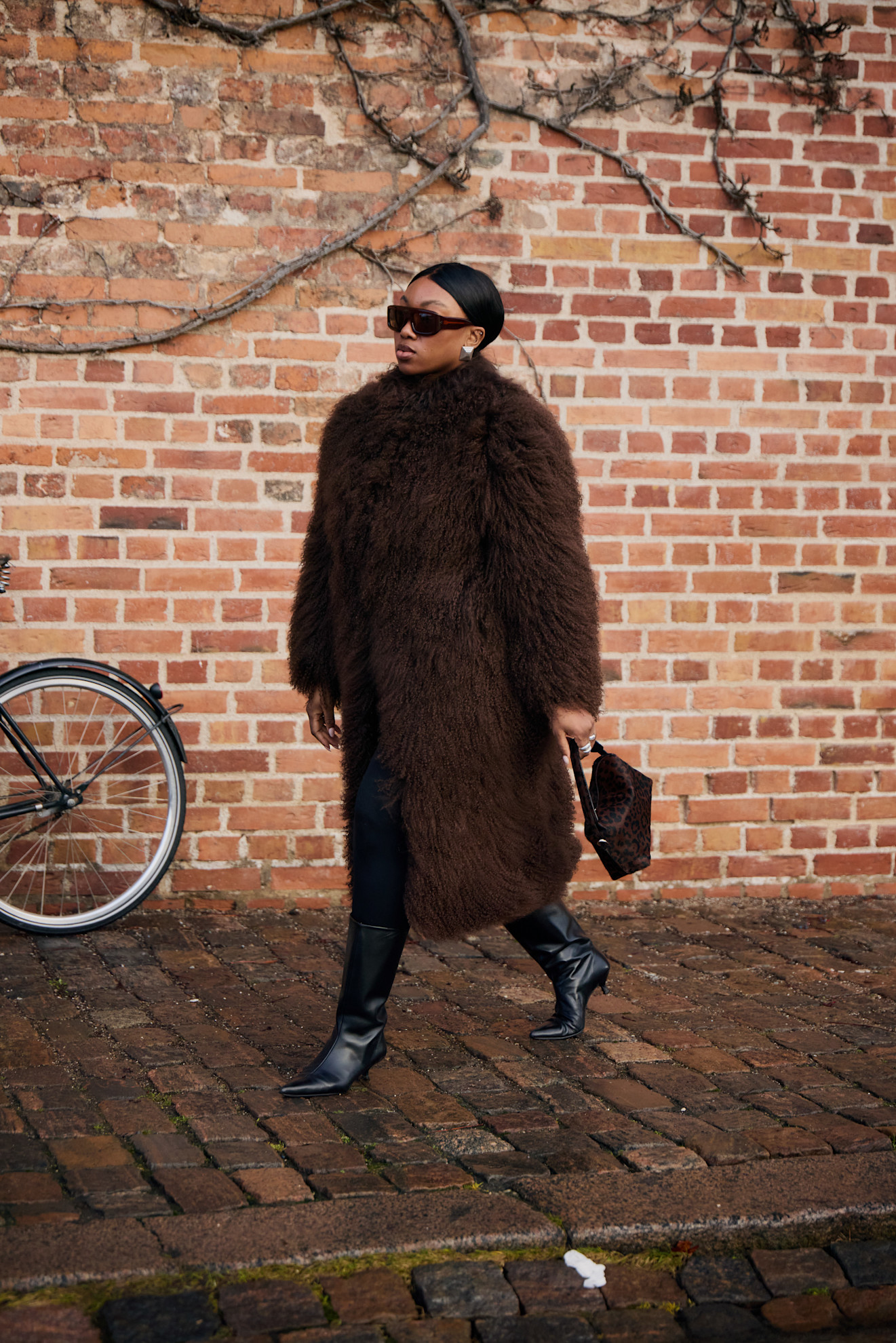 woman wearing a fur jacket and knee-high black boots.