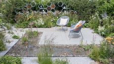 pollinator friendly garden design with pond, insect hotels, white gravel and drought tolerant planting