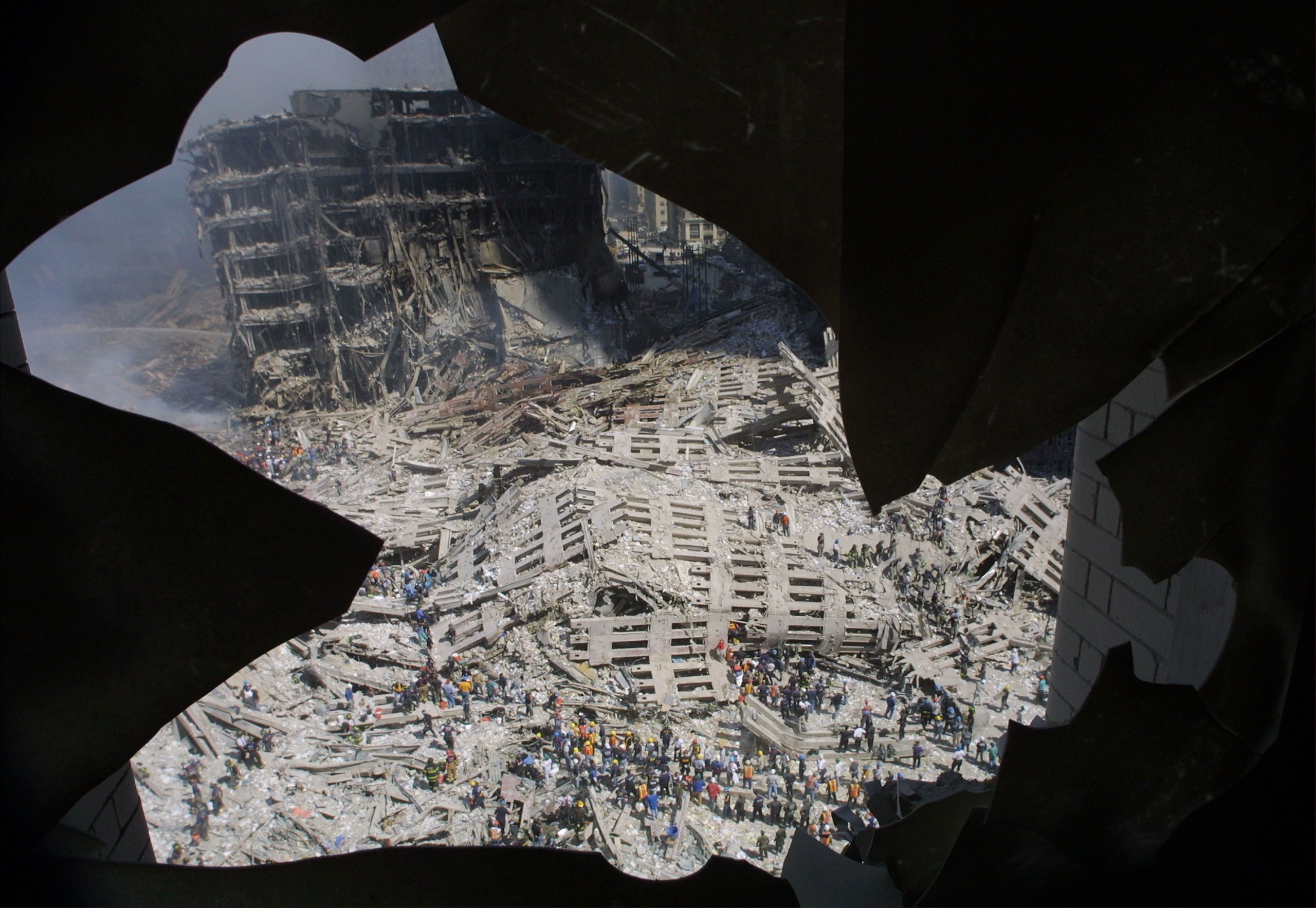 The wreckage of the World Trade Center is visible through the broken window of an apartment building near the wreckage September 13, 2001 in New York City, two days after two airplanes slammed into the twin towers September 11, 2001 in an alleged terrorist attack.