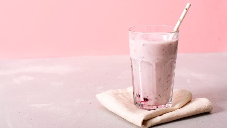 a smoothie on a table cloth against a pink background