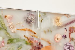 Detail of the Flora cabinet by Marcin Rusak with dried flowers embedded in a white resin surface