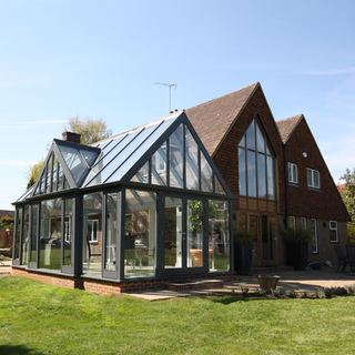 house exterior with glass extension and garden