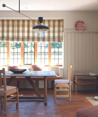 Country style kitchen with check blind in front of dining table