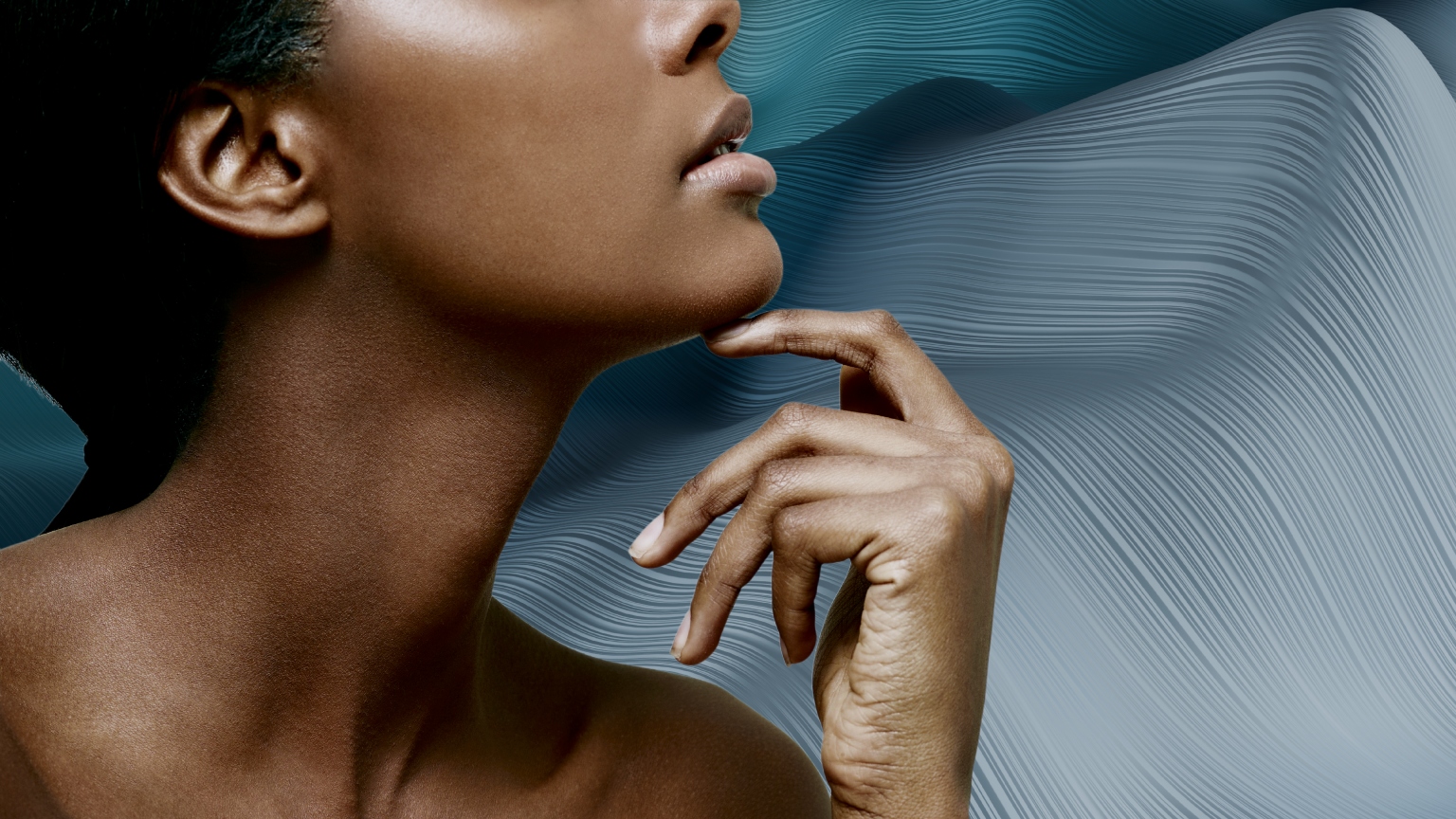 a profile of a woman's neck and chin on a blue backdrop