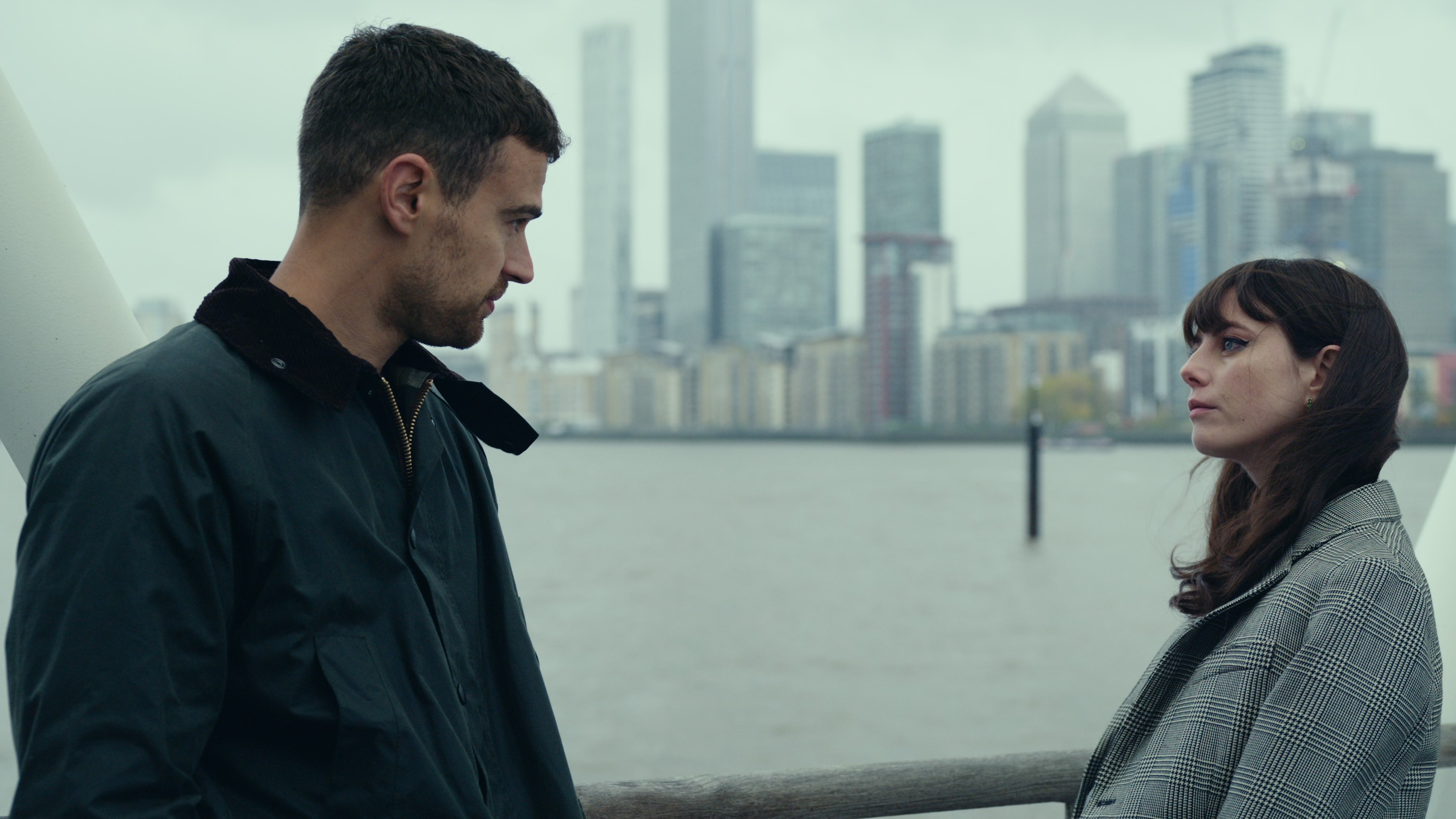 L-R: Eddie (Theo James) and Susie (Kaya Scodelario) meet on a bridge in a scene from Netflix's "The Gentlemen"