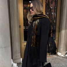 Christina Grasso wearing a printed velvet scarf with a black evening coat