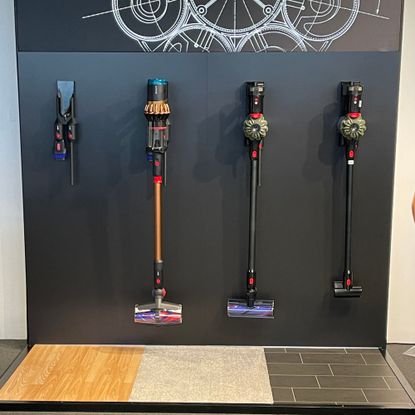 Dyson V16 Piston Animal and Dyson V8 Cyclone hanging on a black wall