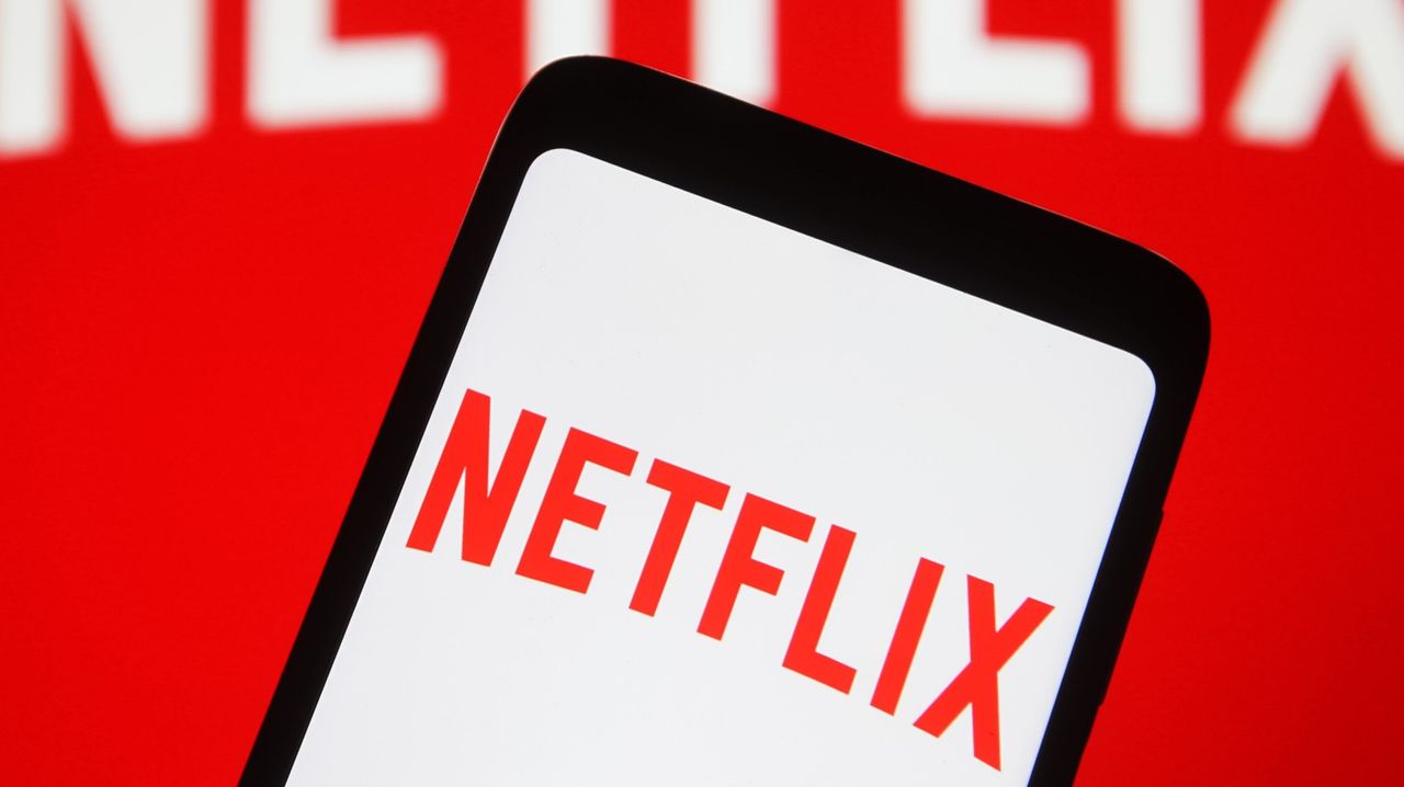 In this photo illustration the Netflix logo seen displayed on a mobile phone and on a pc screen.