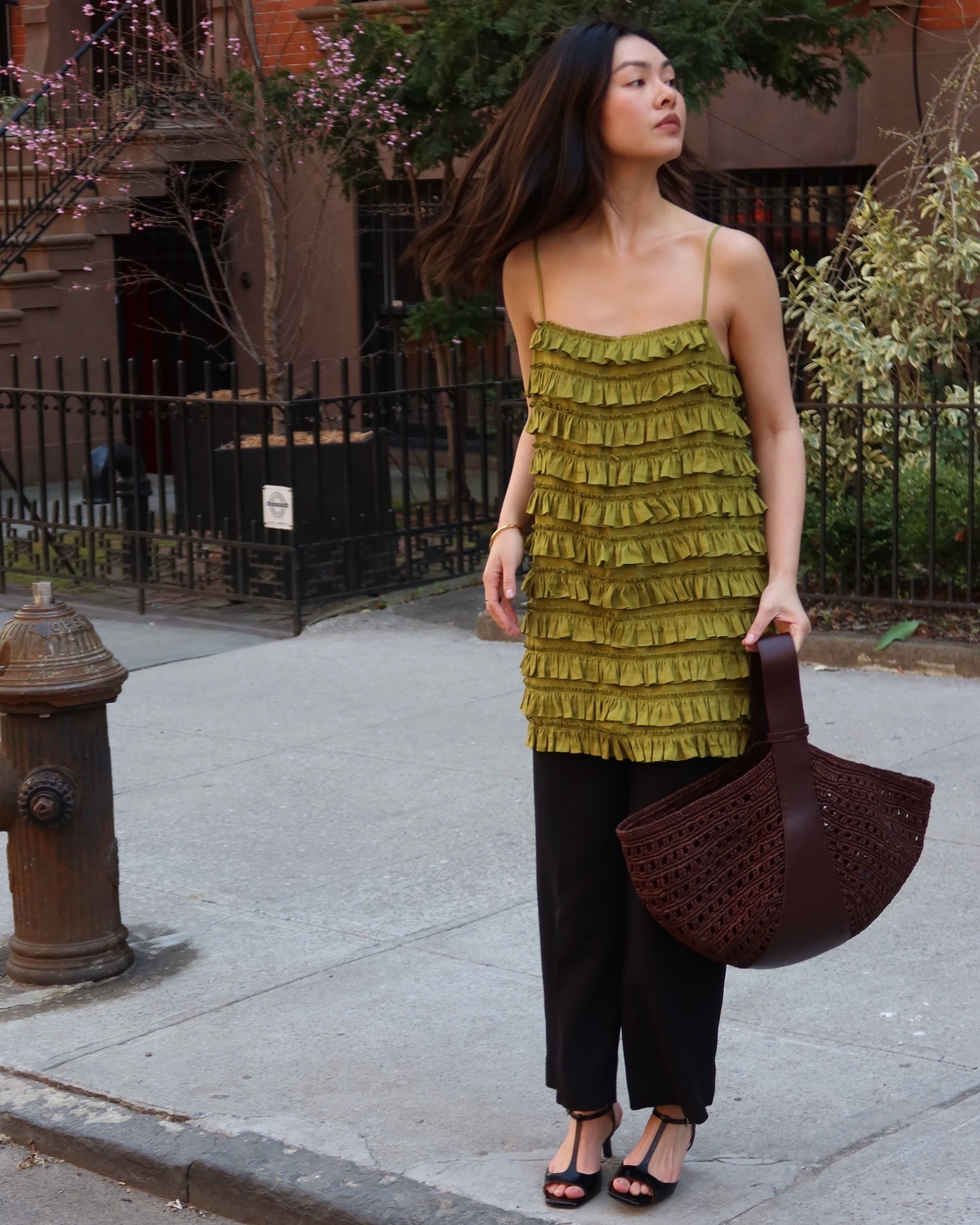 Influencer @mimixn wears a green top with a chocolate brown bag.