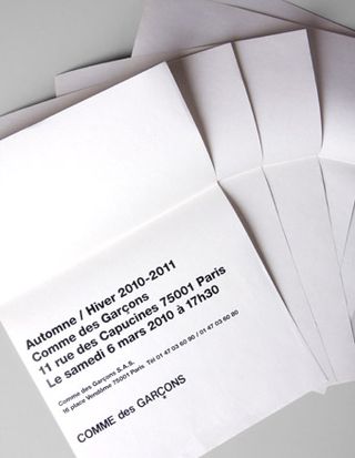 An invitation accompanied by four blank sheets of paper for Comme des Garçons